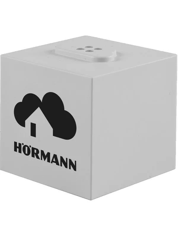 En vit, fyrkantig enhet med en sladd, placerad på en vit bakgrund.