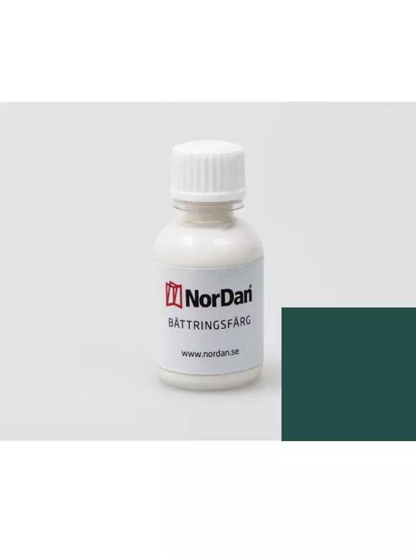 En burk med grön målarfärg och en pensel på ett vitt underlag.