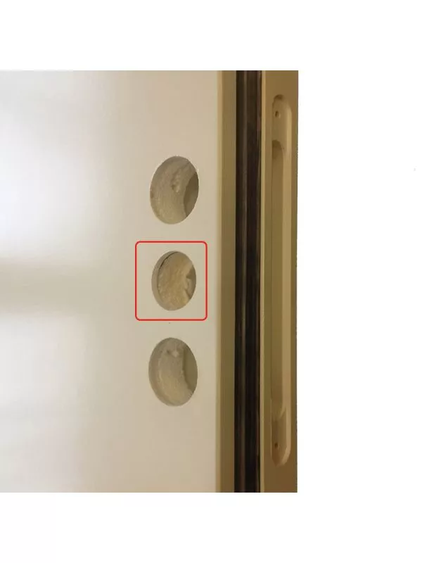 En närbild av en metallcylinder med flera borrade hål i olika storlekar.