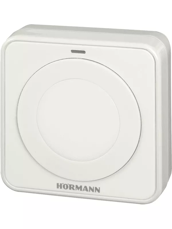 En vit, rektangulär tryckknapp med en grå cirkel i mitten, placerad mot en vit bakgrund.